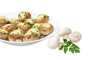 Stuffed button mushrooms on white dish and several uncooked mushrooms