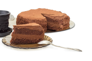 Piece of chocolate cake on saucer and rest of cake