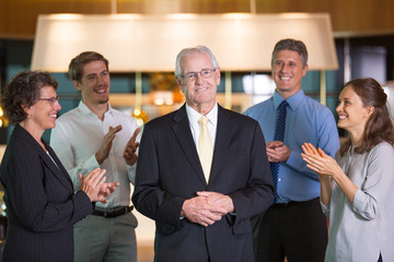 Colleagues Applauding to Senior Business Leader