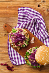 Burger with meat of duck with red onion and lettuce.