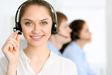 Call center operators. Focus at brunette business woman in headset