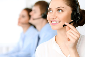 Call center operators. Focus at brunette business woman in headset