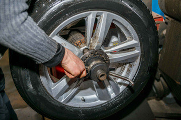 Professional auto mechanic makes balancing vehicle wheels