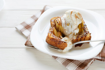 Delicious homemade dessert. Baked toast with apples and ice cream drizzled with chocolate