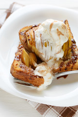 Delicious homemade dessert. Baked toast with apples and ice cream drizzled with chocolate