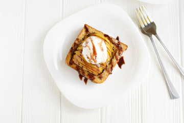 Delicious homemade dessert. Baked toast with apples and ice cream drizzled with chocolate