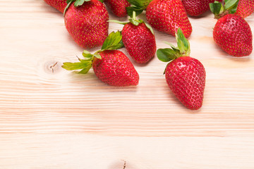 red strawberries on a wooden table, the bottom place for an inscription