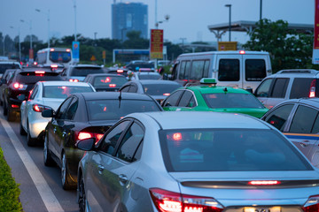 Obraz na płótnie Canvas Cars on urban street in traffic jam at twilight