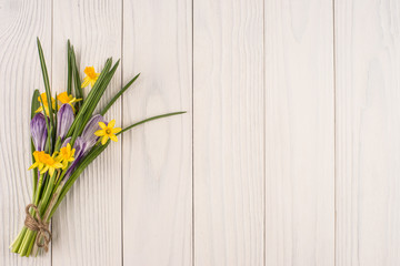 Daffodils and crocuses on the old white wooden table.
