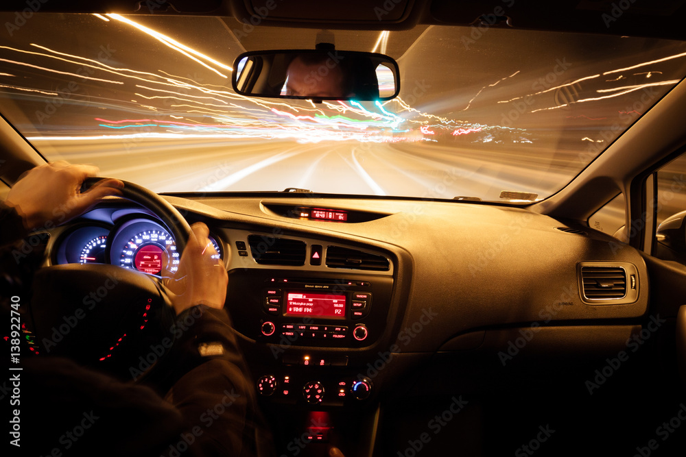 Wall mural night driving, view from inside car, city and other cars light is motion blurred.