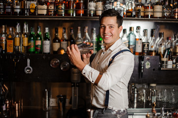 smiling bartender is mixing coctail