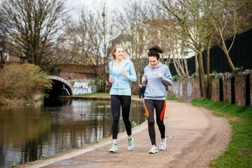 Muurstickers Two girls jogging outdoors in London © Riccardo Piccinini