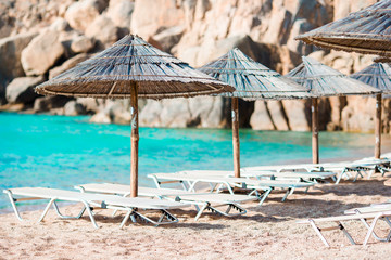 Beach wooden chairs and umbrellas for vacations on beach in Greece