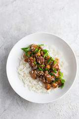 teriyaki chicken with rice, served with sesame seeds and chopped green onions