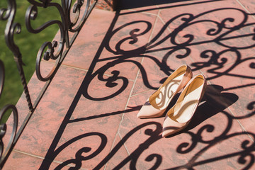 Stylish beige female leather shoes in shadows and sunlight. Modern ffotwear fashion classics.