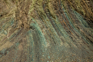 Layered sedimentary rock texture of a cliff shore with many colors for individual layers