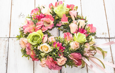 Wedding wreath with roses on white wooden background