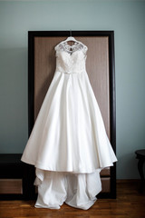 Fototapeta na wymiar beautiful white dress for the bride hanging on the closet