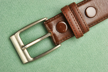 leather belt with a buckle on a green background