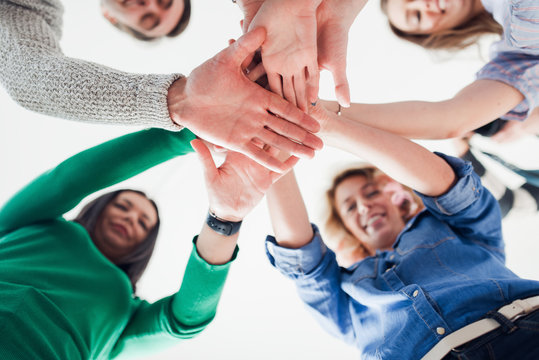 Top view of co-workers hand put together in an expression of unity and team spirit
