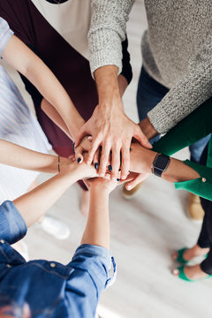 Top view of co-workers hand put together in an expression of unity and team spirit