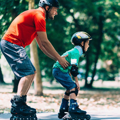 Father teching son roller skating