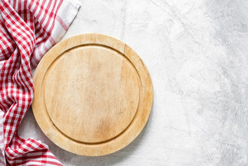 Old round wooden cutting board and red checkered tablecloth on gray concrete background with copy space for text. Cooking food, kitchen utensil, food background. Top view, Horizontal image - obrazy, fototapety, plakaty
