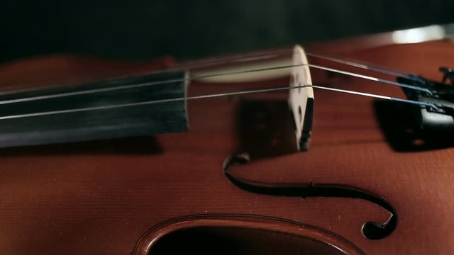 close up rotation shot of part of aged violin on black background
