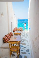 Benches with pillows in a typical greek outdoor cafe in Mykonos with amazing sea view on Cyclades islands