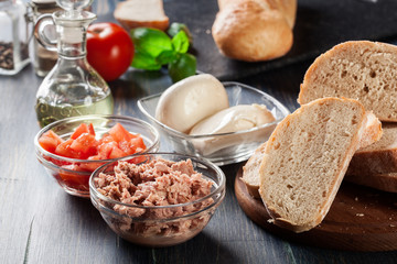 Ingredients ready for preparing bruschetta with tuna, mozzarella cheese and tomatoes