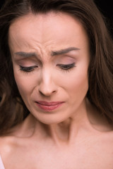 Fototapeta premium Close-up portrait of beautiful young woman crying and looking down
