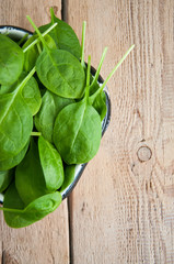 Fresh baby spinach leaves on a wooden background