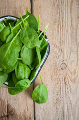Fresh baby spinach leaves on a wooden background