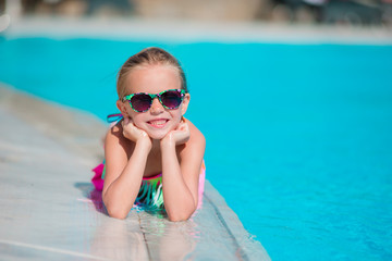 Little happy girl enjoy vacation in outdoor swimming pool