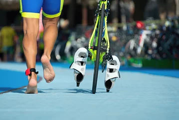 Photo sur Plexiglas Vélo Triathlete running with your bike the transition zone,detail of the legs
