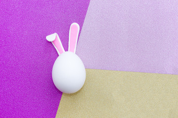 Easter egg with Bunny ears on colorful background.