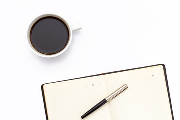 the black open diary, pen and a Cup of black coffee on white background