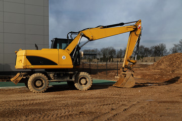 yellow excavator works on a construction site