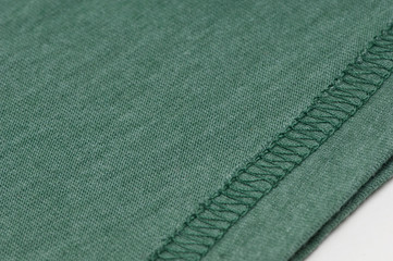 closeup of sewing the seam on green fabric
