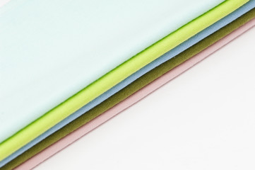 background of colorful fabrics and textiles stacked on one another