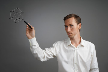 Young male scientist working with a model of the atom.