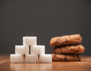 Amounts of Sugar In Food - Chocolate Chip Cookies, On wooden table and dark Background, Selective Focus