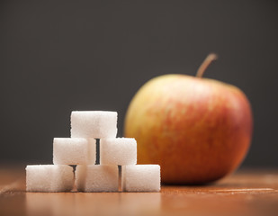 Amounts of Sugar In Food - Apple, On wooden table and dark Background, Selective Focus