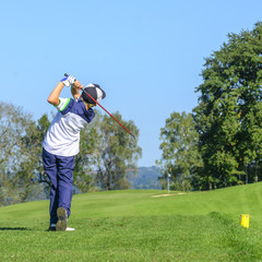 Jugendlicher beim Abschlag auf dem Golfplatz