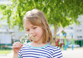 Child smelling flowers in the spring.