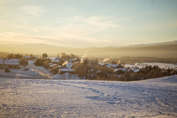 A beautiful morning panorama of a small Norwegian town during sunrise with a flares and warm look
