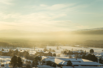 A beautiful morning panorama of a small Norwegian town during sunrise with a flares and warm look