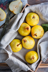 Fresh yellow pear in a wooden box, top view