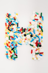 Top view of letter H made from medical pills and capsules, medicine and healthcare concept