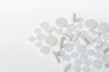 Assortment of white medical tablets and capsules, medicine and healthcare concept